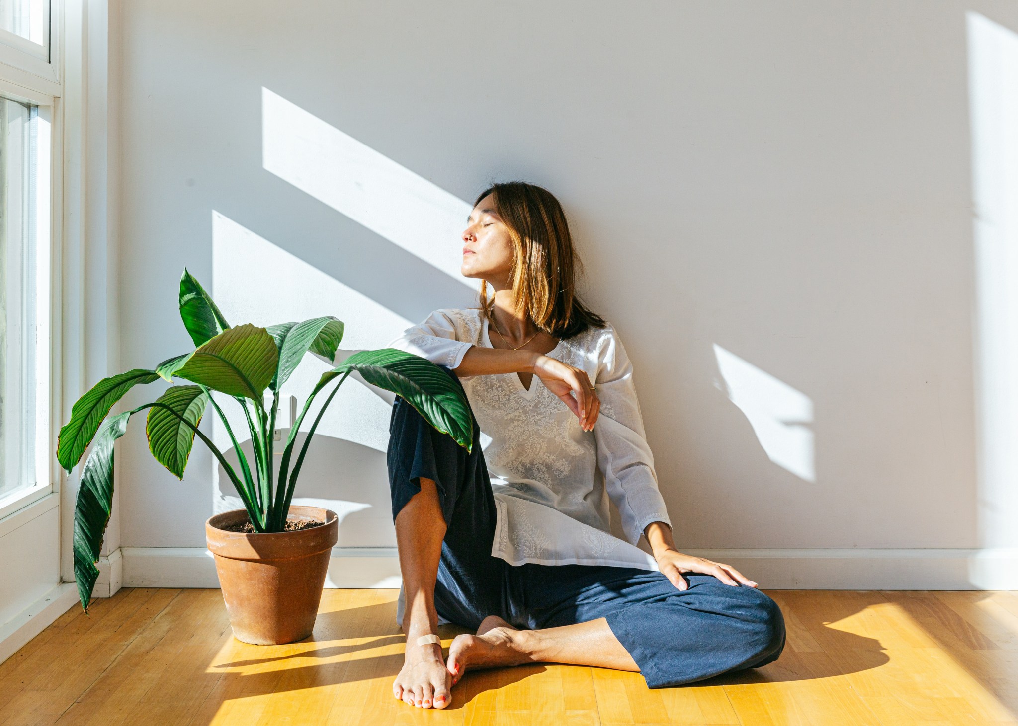 Mujer sentada al sol, tranquila sobre su salud.